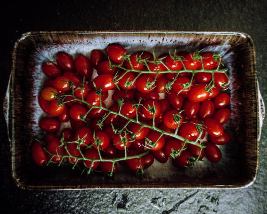 Blaue Ofenform mit roten Tomaten in einer soñho Ofenform